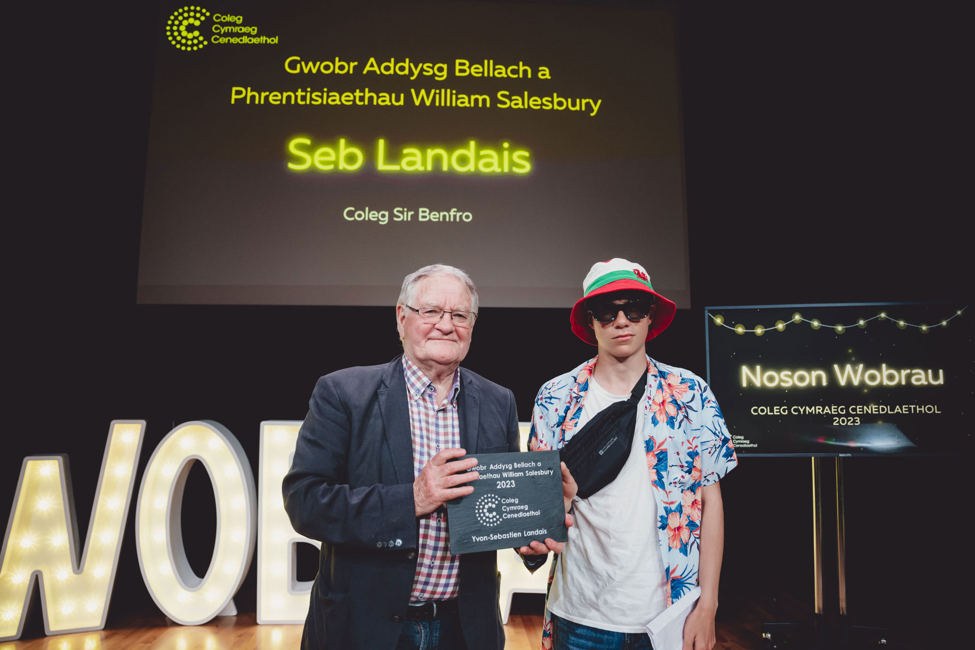 Dafydd Iwan yn cyflwyno gwobr i Seb Landais, Coleg Sir Benfro