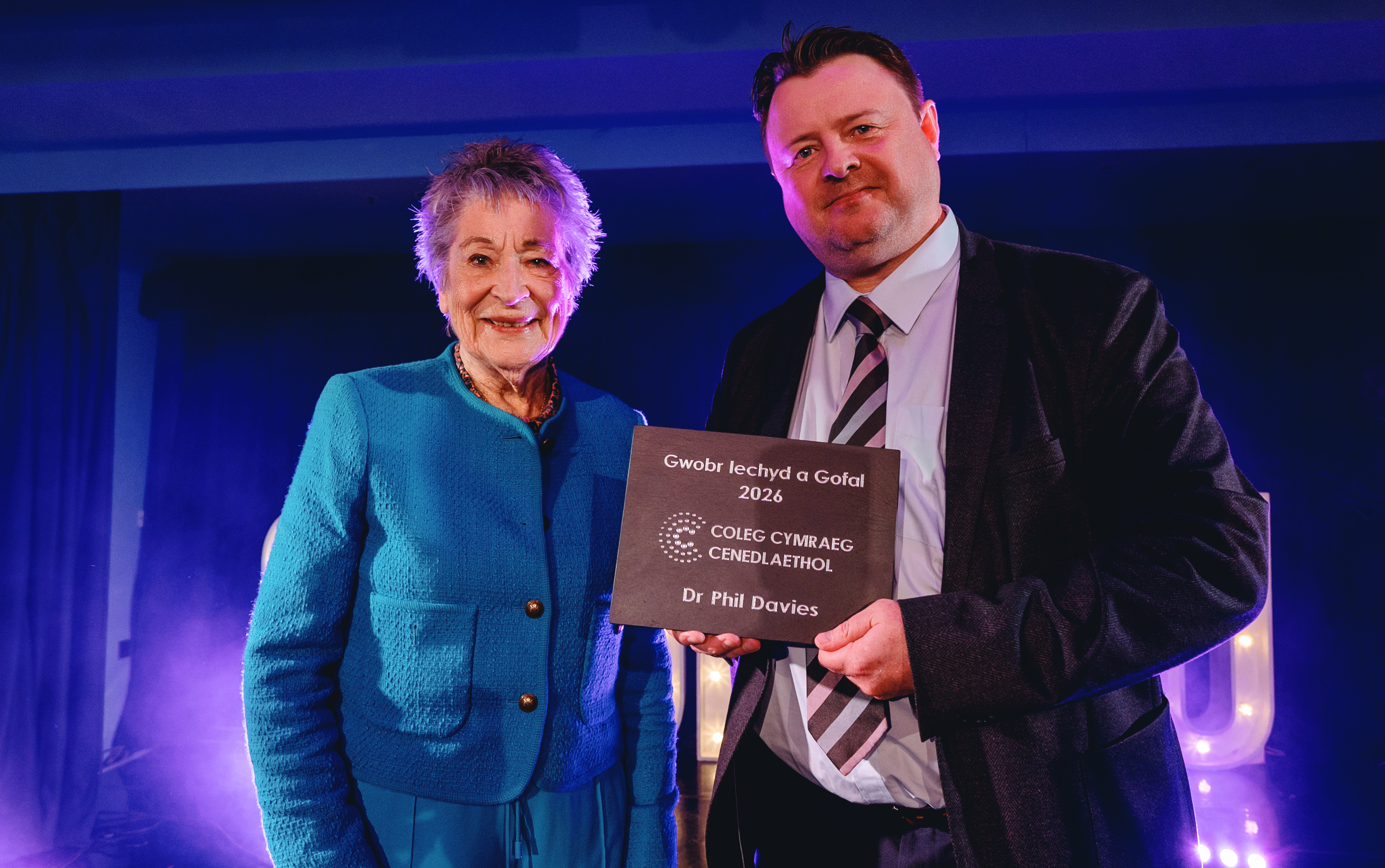 Beti George yn cyflwyno gwobr Iechyd a Gofal i Dr Phil Davies